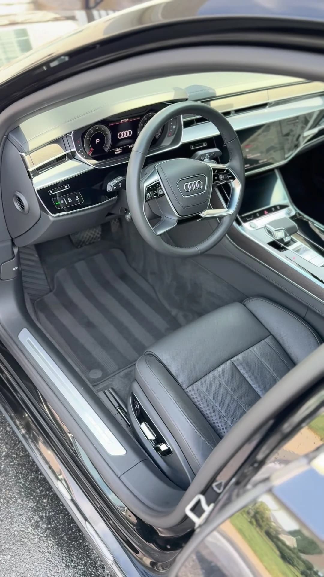 Audi A8L cabin with clean black leather seats, carpets and dashboard