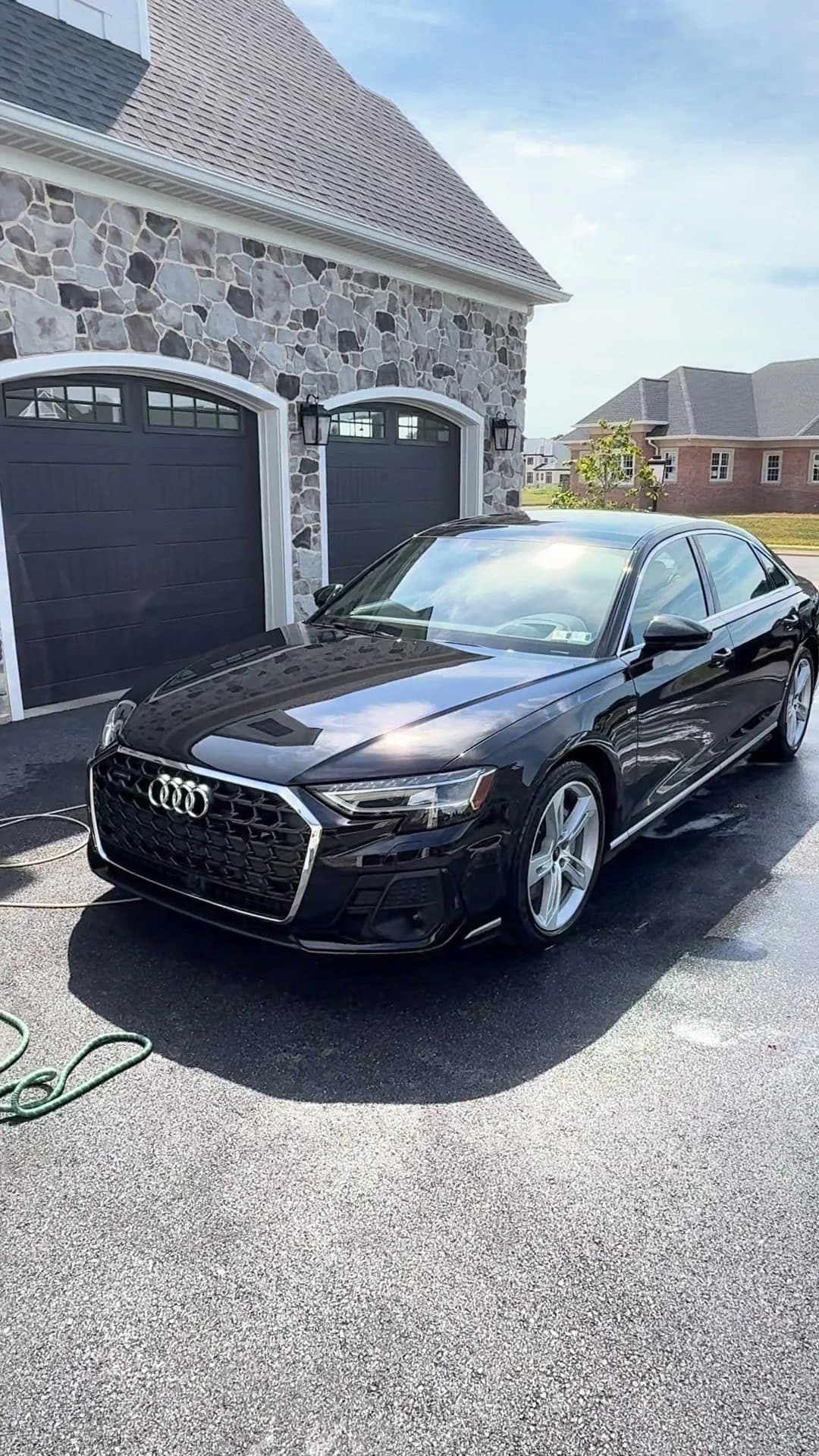 Black Audi A8L with clean paintwork and wheels in a customer driveway