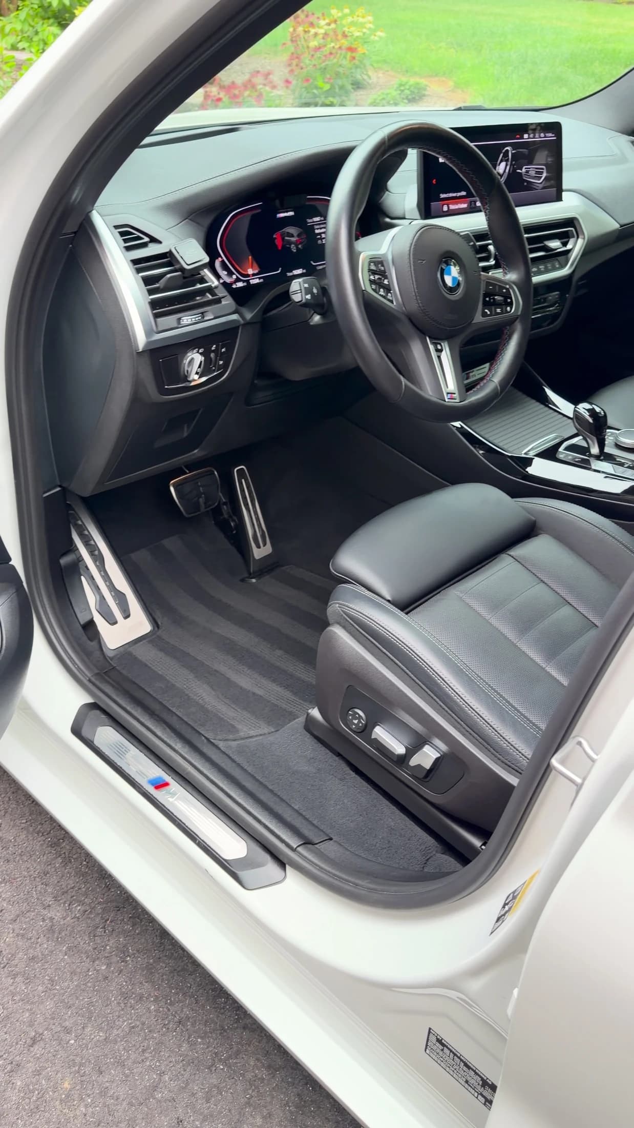 Detailed BMW front cabin with black leather driver seat and steering wheel