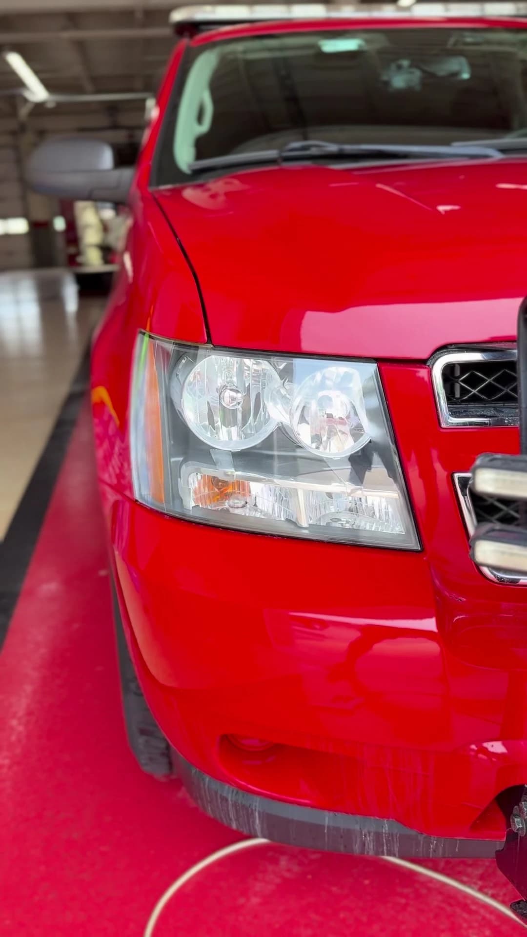 Clear headlight lens on the same red truck after restoration