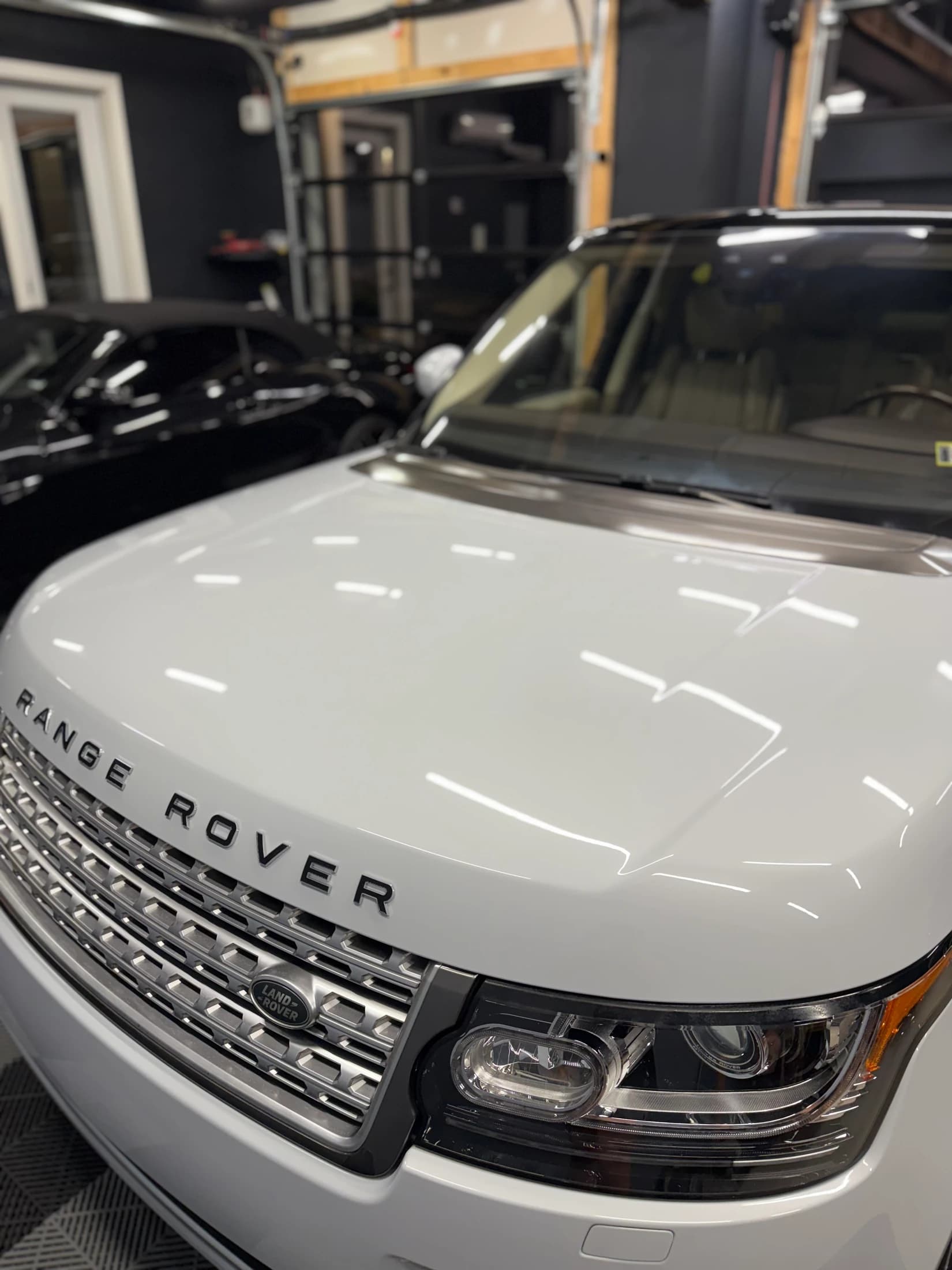 Reflections across a white Range Rover hood and front bodywork